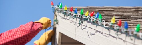 Homeowner installing Christmas lights