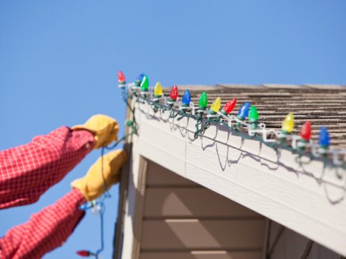 Homeowner installing Christmas lights